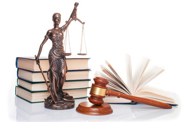 statue of justice, judge's hammer behind books on a white background