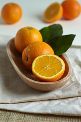 Oranges in a wooden bowl with leaves