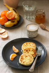Vegetarian breakfast of quark pancakes with honey, fruit and coffee with milk. Rustic style.