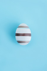 Striped egg on wooden background, Easter concept.