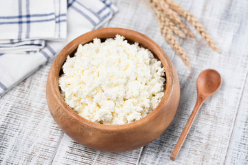 Cottage Cheese or Tvorog in bowl. Rich in Calcium healthy food, dairy product. On white wooden background. Closeup view