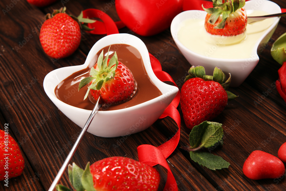 Wall mural Valentine Chocolate fondue melted with fresh strawberries and dark and white chocolate. Tublips and sugar hearts.