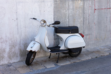 Old scooter on concrete wall background