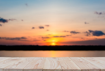 Fototapeta na wymiar Empty wooden board table top on of blurred sunset and lake background. with copy space for display or montage your products