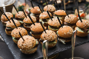 Small burgers served on one plate as appetizers