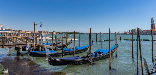 Obraz na płótnie Canvas Gondolas moored by Saint Mark square in Venice, Italy at claudy day