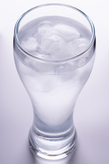 water with ice cubes in glass. white background