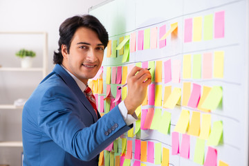 Young handsome employee with many conflicting priorities