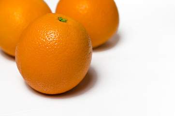 Three juicy oranges lie on a white background