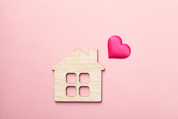 Obraz na płótnie Canvas wooden house and pink heart, creative Valentine's day card, love and family concept