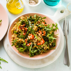 rice salad with baked bell peppers, arugula, olives and capers. Healthy vegan spring recipe for the whole family or party