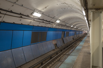 Blue tiled wall in underground subway station in large urban area