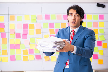 Young handsome employee with many conflicting priorities