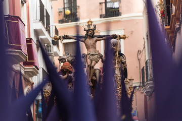 Fototapeta na wymiar Nazarenos carrying sculpture of crucified Jesus Christ during Easter procession at Sevilla, Spain