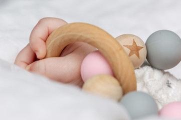 Close-up of a baby´s hand, playing with a wooden toy.