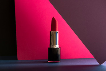 Elegant make-up stills, pink lipstick on colorful geometric background.