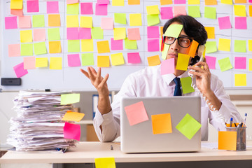 Young employee in conflicting priorities concept
