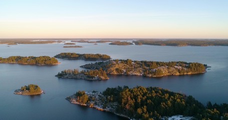 Drone shot, of frosty, first snowy islands, at sunset, at the Gulf of finland, on a sunny, cold, fall evening, Varsinais-suomi, Suomi.
