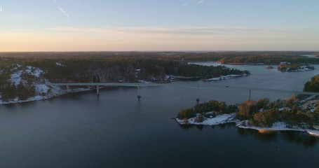 Drone shot, towards a road and a lot of islands, on the gulf of Finland, at sunset, on a sunny, cold, autumn evening, Varsinais-suomi, Suomi