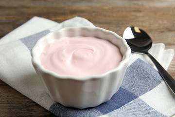 Bowl with creamy yogurt served on table