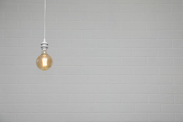 Lamp bulb near brick wall. Space for text