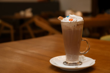 Cup of aromatic cacao on table against blurred background. Space for text