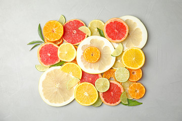 Different citrus fruits on grey background, top view