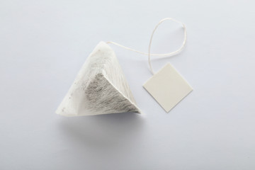 Unused pyramid tea bag with tag on white background, top view. Space for text - Powered by Adobe