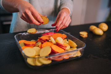 a person cooking potatoes and sweet potatoes in a nice kitchen