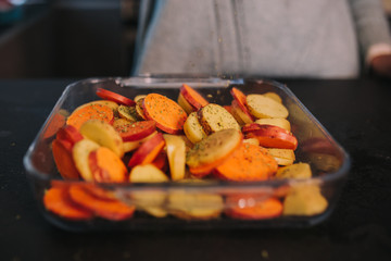 a person cooking potatoes and sweet potatoes in a nice kitchen