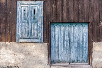 Weathered wood shutters and barn door in wood panel wall