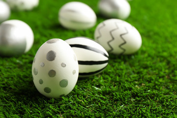 Traditional painted Easter eggs on green lawn, closeup