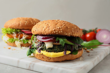 Board with tasty vegetarian burgers on table