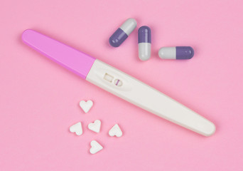 positive result on the pregnancy test over a pink background