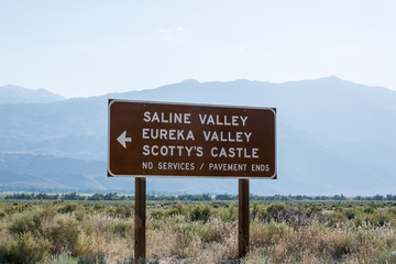 Road sign for Death Valley National Park points of interest - Scotty's Castle, Eureka Valley and Saline Valley. No services on an unpaved dirt road