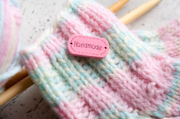 DIY Knitted pink warm wool socks for a newborn girl. Selective focus.