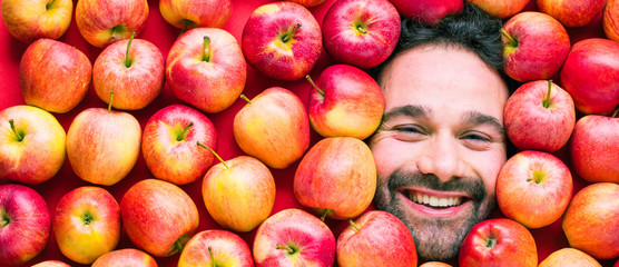 Mann mit Äpfeln , Konzept für Lebensmittelindustrie. Gesicht von lachenden mann  in Apfel Fläche.