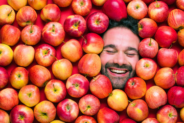 Mann mit Äpfeln , Konzept für Lebensmittelindustrie. Gesicht von lachenden mann  in Apfel Fläche.