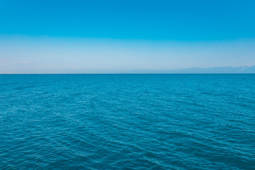 Fototapeta na wymiar Abstract aqua blue sea and blue sky horizon with ocean surface background. Blue sea water. Summer holiday vacation concept image. Aegean or mediterranean sea.