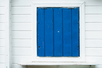 Blue wooden window with white wall