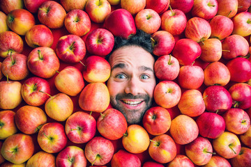 Mann mit Äpfeln , Konzept für Lebensmittelindustrie. Gesicht von lachenden mann  in Apfel Fläche.