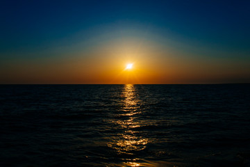 Sunset on the sea or ocean with beautiful blue sky. Sunset or sunrise scene landscape background concept image.