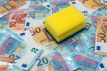 Concept of money laundering, euro banknotes and a yellow scourer