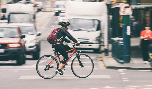 Woman riding bike on city street 