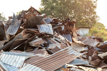 Piles of old zinc roofs with trees early in the morning.