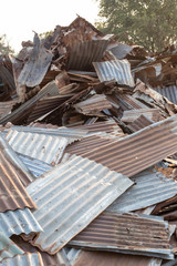 Piles of old zinc roofs with trees early in the morning.