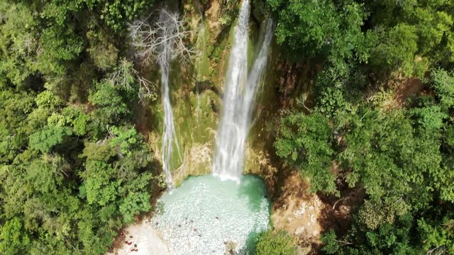 Aerial Descent: People Bathing in Natural Pool under Picturesque Waterfall 