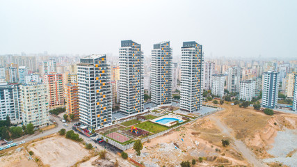 New multi-storey residential building apartment houses aerial view with swimming pool, basketball court and children playground. Mortgage background concept image.
