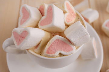 Pink sweet marshmallow hearts in a cup on wooden background. Valentine's day background, close-up