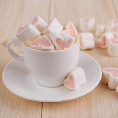 Pink sweet marshmallow hearts in a cup on wooden background. Valentine's day background,